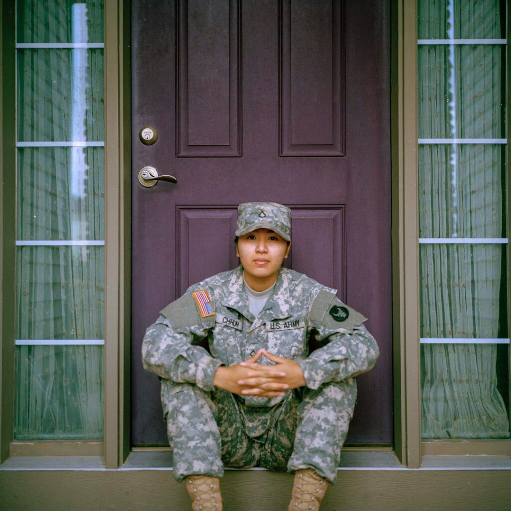 Army veteran woman sitting in front of closed door.